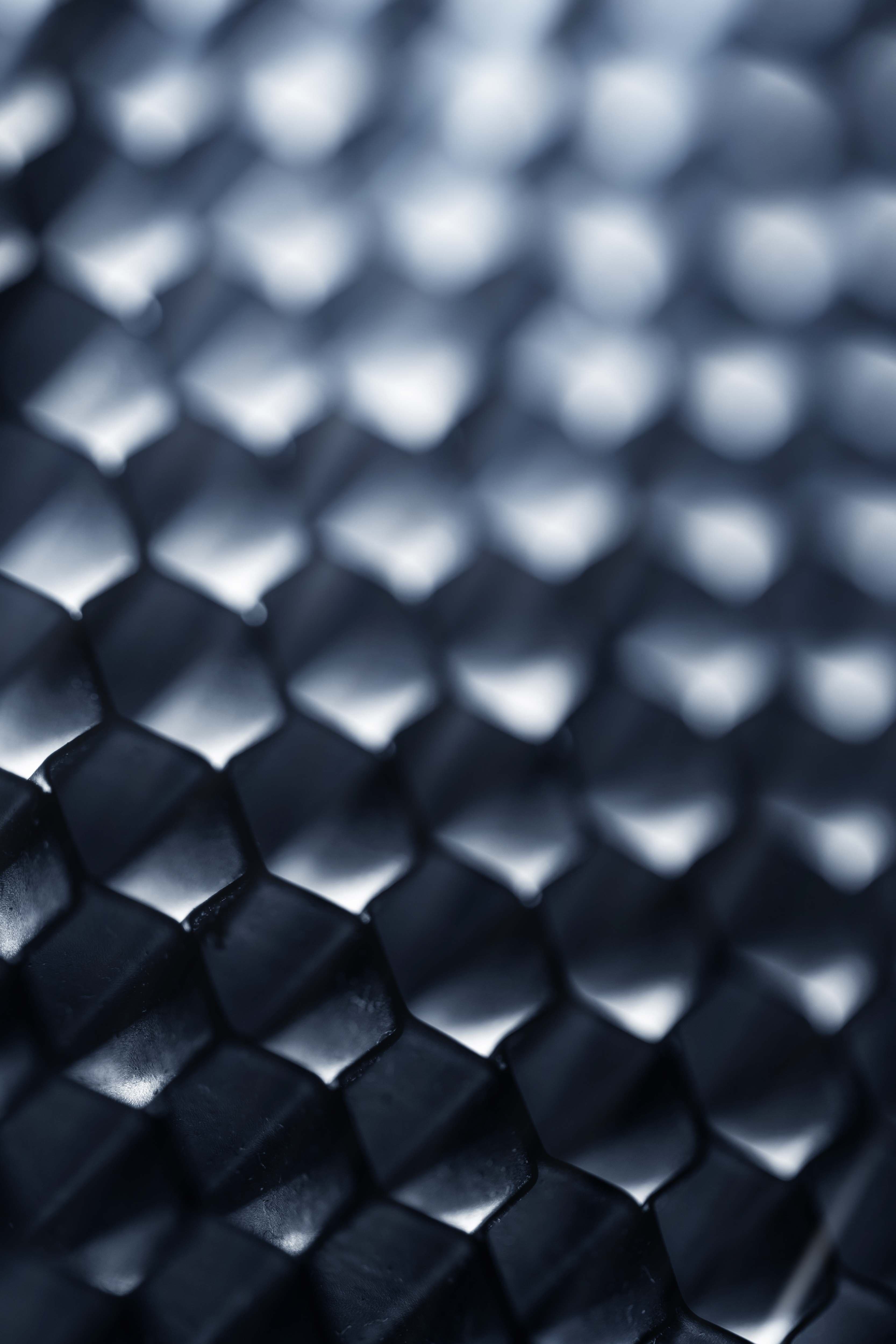 An abstract dark metallic honeycomb structure, evoking a global investment firm